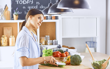 A young woman prepares food in the kitchen. Healthy food - vege