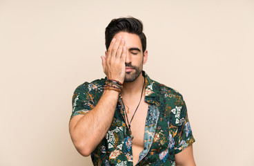 Handsome man in summer shirt over isolated background covering a eye by hand