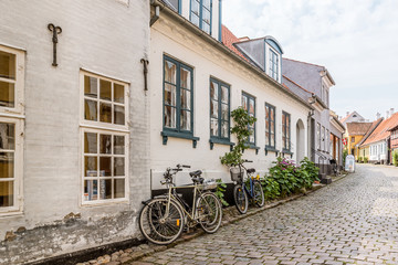 Fototapeta na wymiar bikes on the pavement along the walls of stone houses on a old lane, The island of Aero