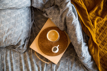 Black coffee in a transparent cup in bed in the autumn morning