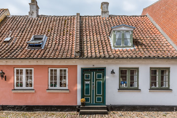 Two small idyllic houses with a beautiful door on an old  street with cobblestone in the danish island of Aero