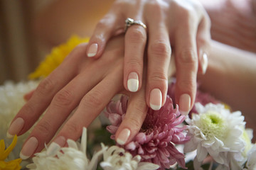 Obraz na płótnie Canvas Beautiful women's hands against the background of flowers. French