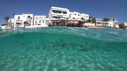 Fototapeta na wymiar Above and below underwater photo of turquoise clear sea of Ammos sandy beach near port of Koufonisi island, Small Cyclades, Greece