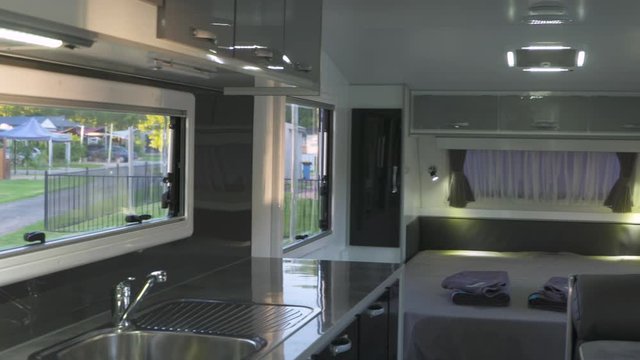 A panning shot showing the classic design of this modern caravan including the kitchen and sleeping arrangements.