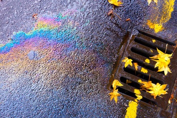 Oil Pollution Spill Running Down Guttering Drain on a Wet Day