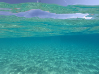 Sea level and underwater photo of tropical exotic sandy beach with turquoise clear sea in popular Caribbean destination