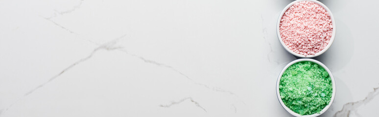 panoramic shot of pink and green powder beauty products on marble surface