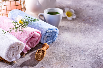 Wellness setting. Sea salt , towel, tea and flowers on stone background. Space for copy.