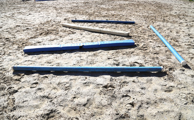 Colorful barriers on the ground for jumping horses and riders at riding school as a background