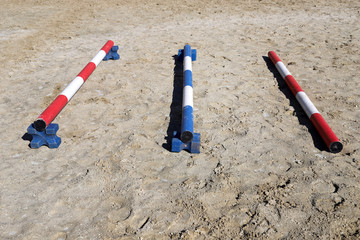 Colorful barriers on the ground for jumping horses and riders at riding school as a background