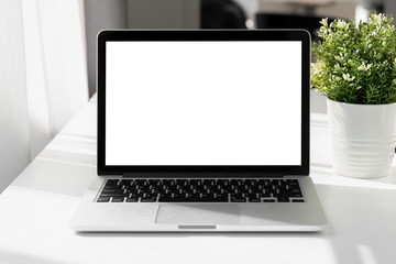 Laptop with blank screen on white table