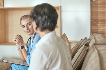 Obraz premium Friendly smiling doctor and patient sitting on the couch. Very