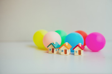 Closeup miniature house with colorful ball background using as property real estate and family concept