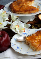 Homemade apple pie bathed with peach jam and honey. White flowers, jar of peach jam and honey....