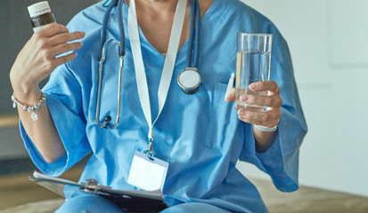 Beautiful smiling woman the doctor in a bottle of pill offers t