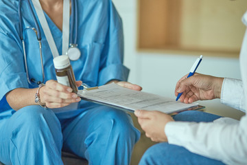 Beautiful smiling woman the doctor in a bottle of pill offers t