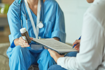 Beautiful smiling woman the doctor in a bottle of pill offers t