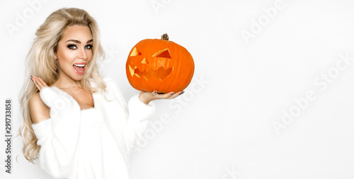 Surprised woman with beautiful face and blond hair holding pumpkin in studio on white background. Halloween concept - Image