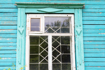 old wooden window with iron bars in an abandoned wooden house
