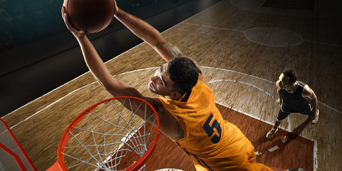 Two basketball players plays near the hoop. High angle view from the basketball rim	