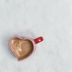 two cup of coffee in the heart form in the snow. New Year Christmas and winter concept