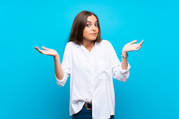 Young woman over isolated blue background making doubts gesture