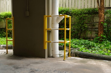 Corner guard or column protector made from stainless steel plates and cages attached to concrete column and surround water pipe in parking area. This can reduce damages cause by c