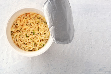 Plastic cup of instant soba noodles, overhead shot with copy space. A metaphor for a dinner for one
