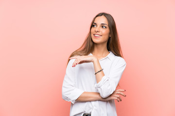 Fototapeta premium Young woman over isolated pink background laughing