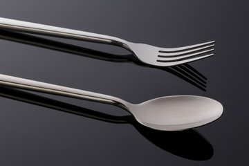 fork and spoon on black