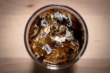 Top view of coffee and milk in glass on a wooden board background