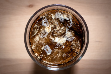 Top view of coffee and milk in glass on wooden board background