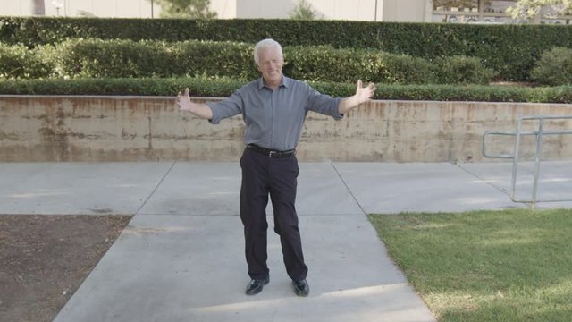 Closeup full portrait of fun elderly guy dancing around, isolated outdoors outside background