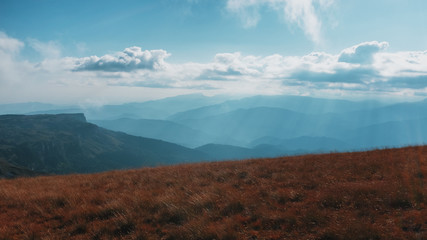 Fototapeta premium Route through mountain peaks and hills through majestic landscapes. Active tourists, hiking