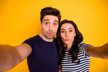 Obraz premium Photo of charming cute lovely nice couple of spouses fooling with their new camera while isolated with yellow background