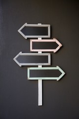 Wooden signpost with four framed arrows directing to the right and to the left.