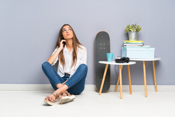 Young woman sitting on the floor thinking an idea