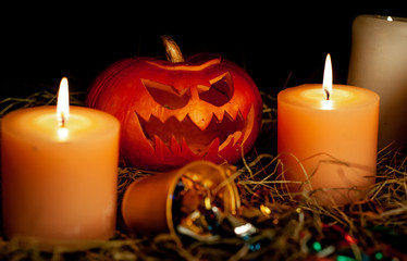 Halloween pumpkin and candles on a table with a straw