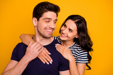 Photo of rejoicing toothy overjoyed nice cute good kind friendly couple in love with each other hugging embracing while isolated with yellow background