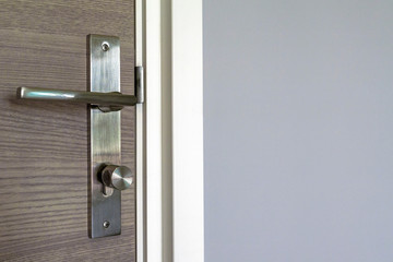 Brown door with stainless steel handles, unlocking the entrance.