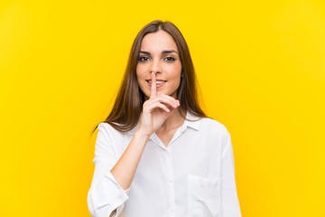 Young woman over isolated yellow background doing silence gesture