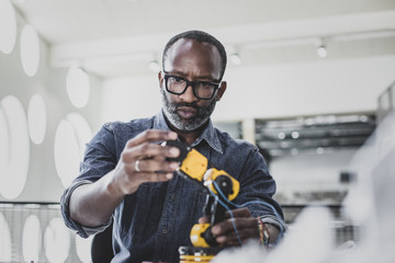 Closeup ofAfrican American adult male working on robotics