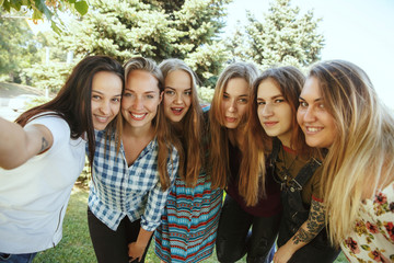 Obraz premium Different and happy in their bodies. Young women smiling, talking, walking and having fun together outdoors on sunny summer's day at park. Girl power, feminism, women's rights, friendship concept.