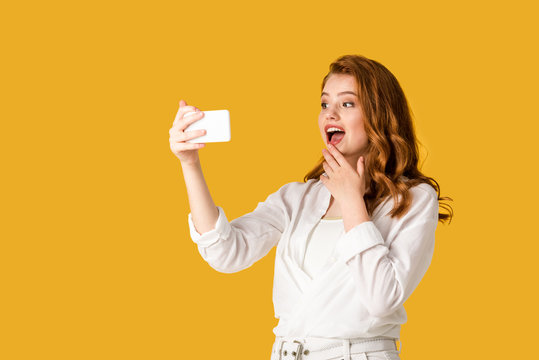 Excited Redhead Girl Taking Selfie Isolated On Orange