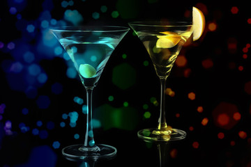 Martini Glasses with olive and lemon piece  on a black background. Selective focus.
