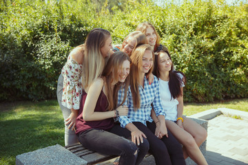 Different and happy in their bodies. Young women smiling, talking, walking and having fun together outdoors on sunny summer's day at park. Girl power, feminism, women's rights, friendship concept.