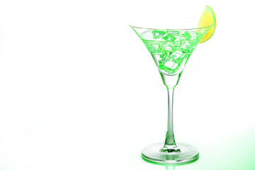Green  Martini glasses with piece of  lemon and ice on white background. Close up. Selective focus.