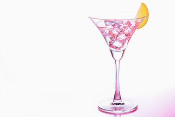 Pink Martini glasses with piece of  lemon and ice on white background. Close up. Selective focus.
