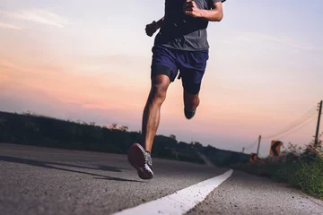 Poster Athlete runner feet running on road, Jogging concept at outdoors. Man running for exercise. © sutadimages