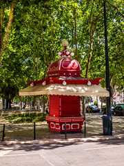 Antique red kiosk in the sidewalk